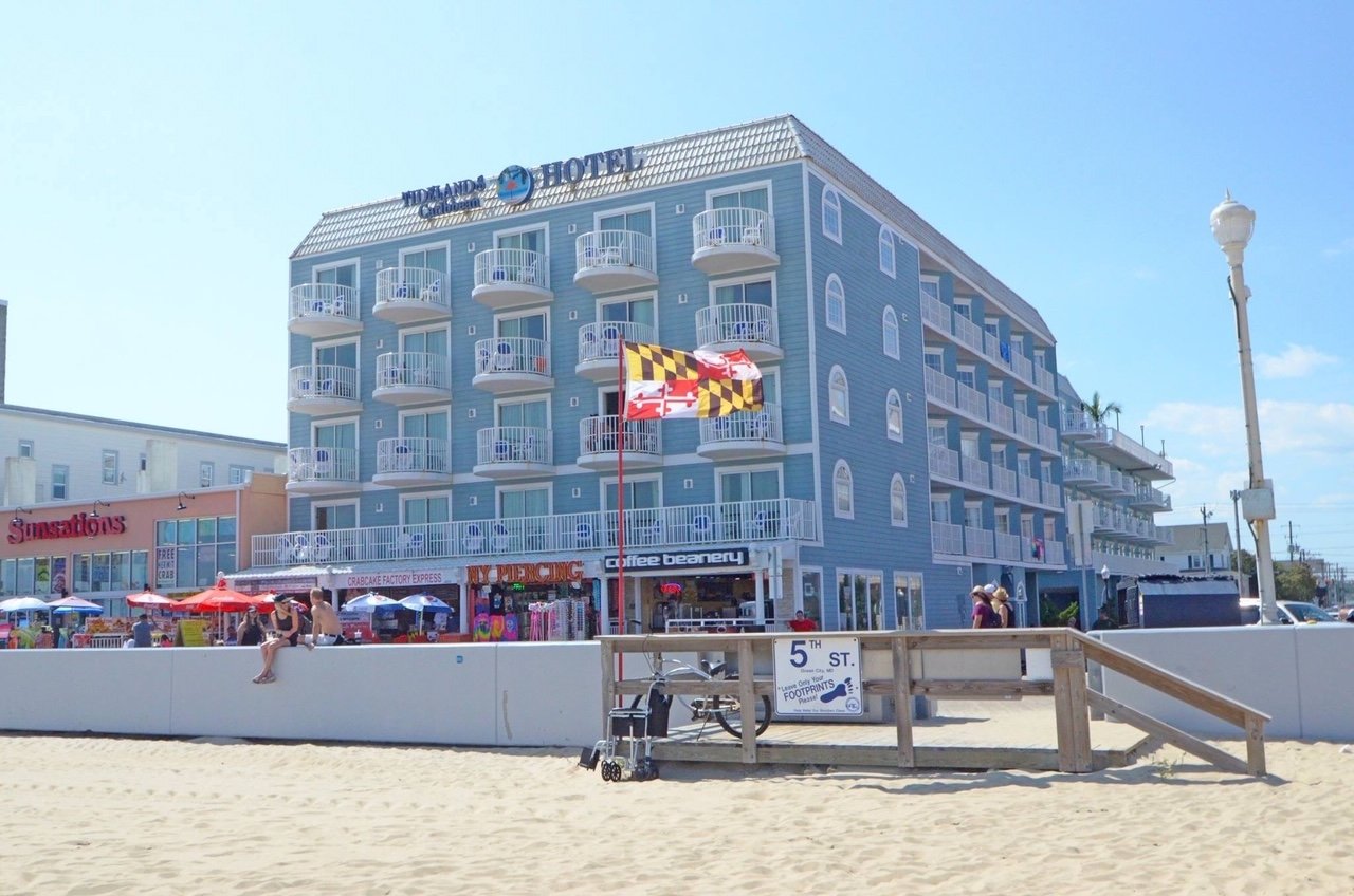 a hotel on the beach with people walking around